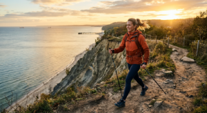 A professional, editorial-style photograph of a person practicing Nordic walking on the scenic cliff