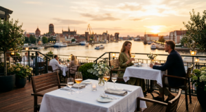 An elegant, professional editorial shot of a high-end restaurant terrace overlooking the scenic Gdań